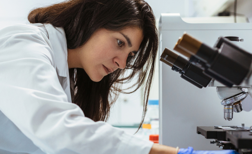 A female scientist at Viome Labs looking into a microscope